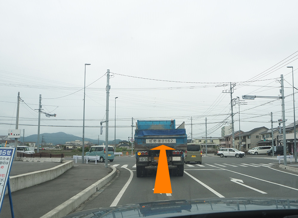 信号のある交差点（左手にピエロという美容院が見えます）に来たら、信号を越え更にまっすぐ180mほど進みます。信号を越えた先の道は細くなります。